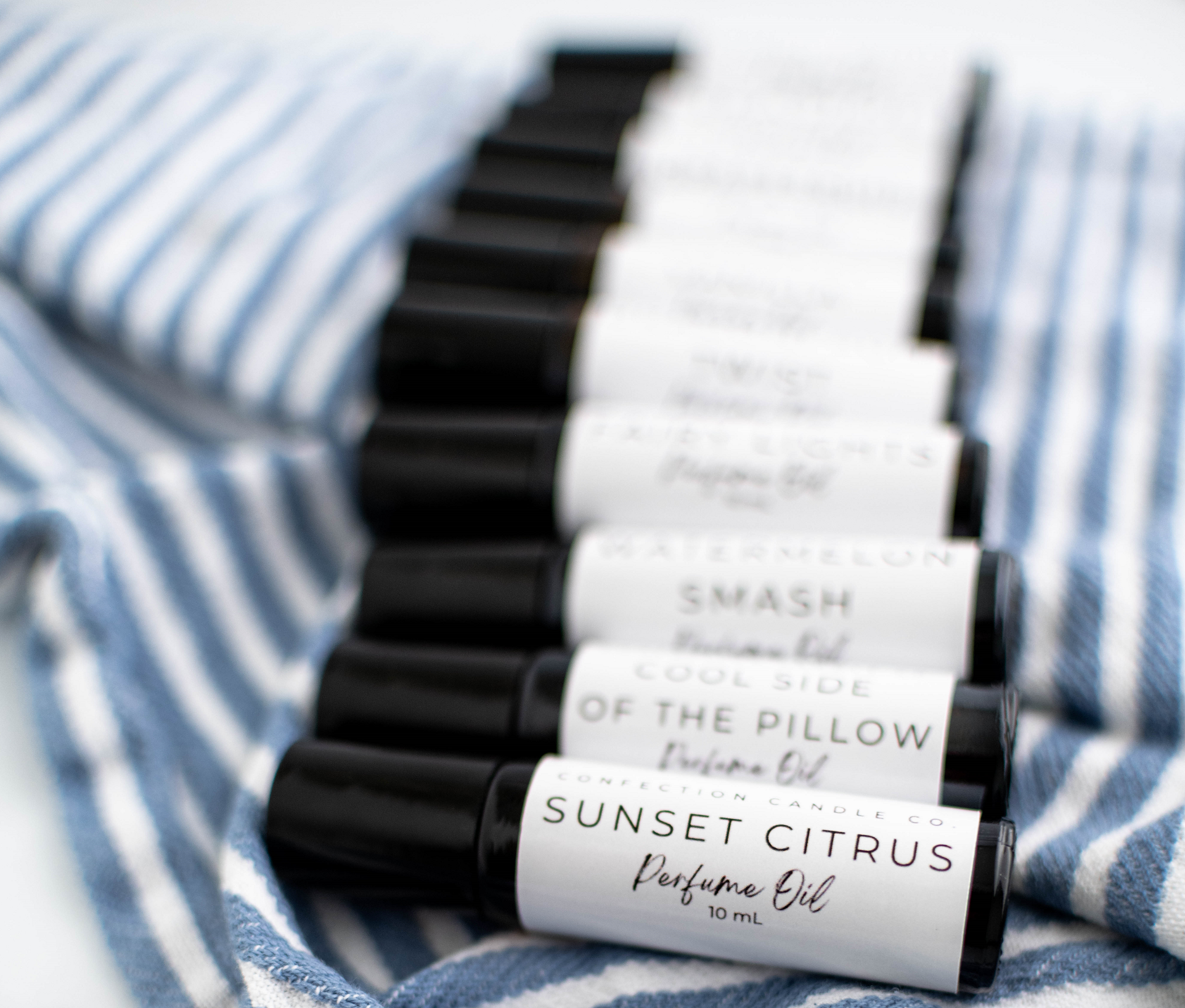 Amber glass roller bottles laying on a blue and white striped towel.