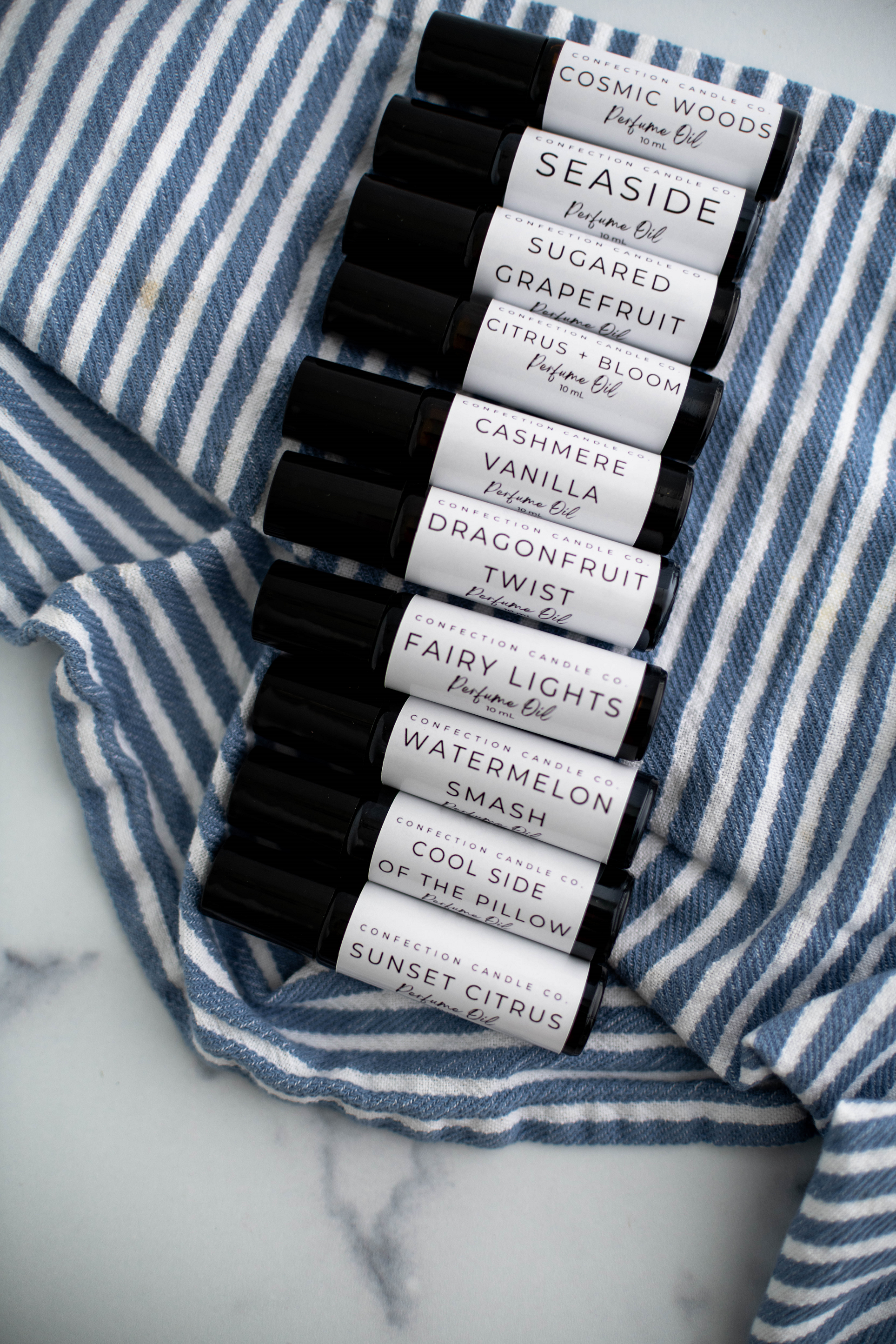 Amber glass roller bottles laying on a blue and white striped towel.