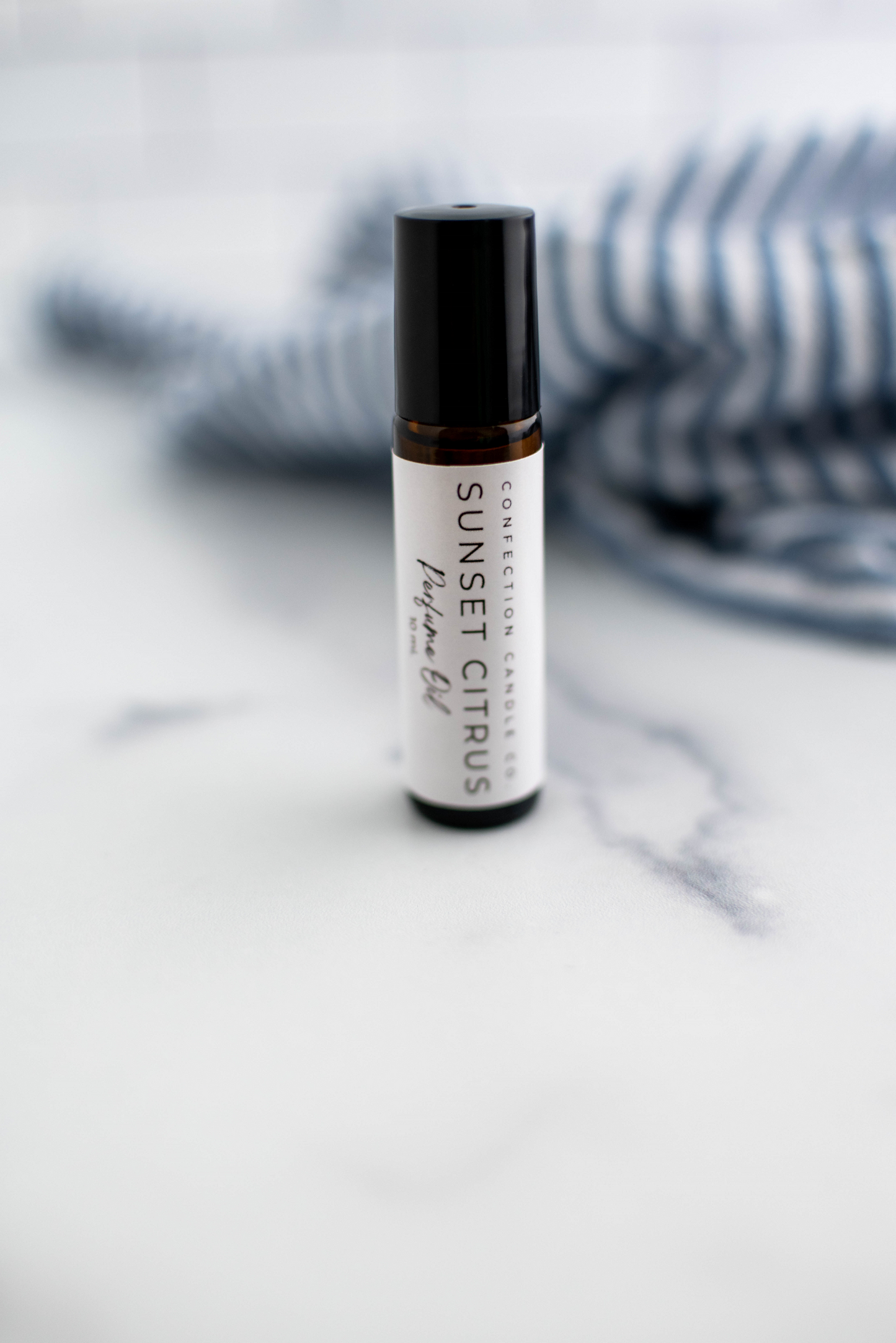 Amber glass roller bottle in the fragrance Sunset Citrus..