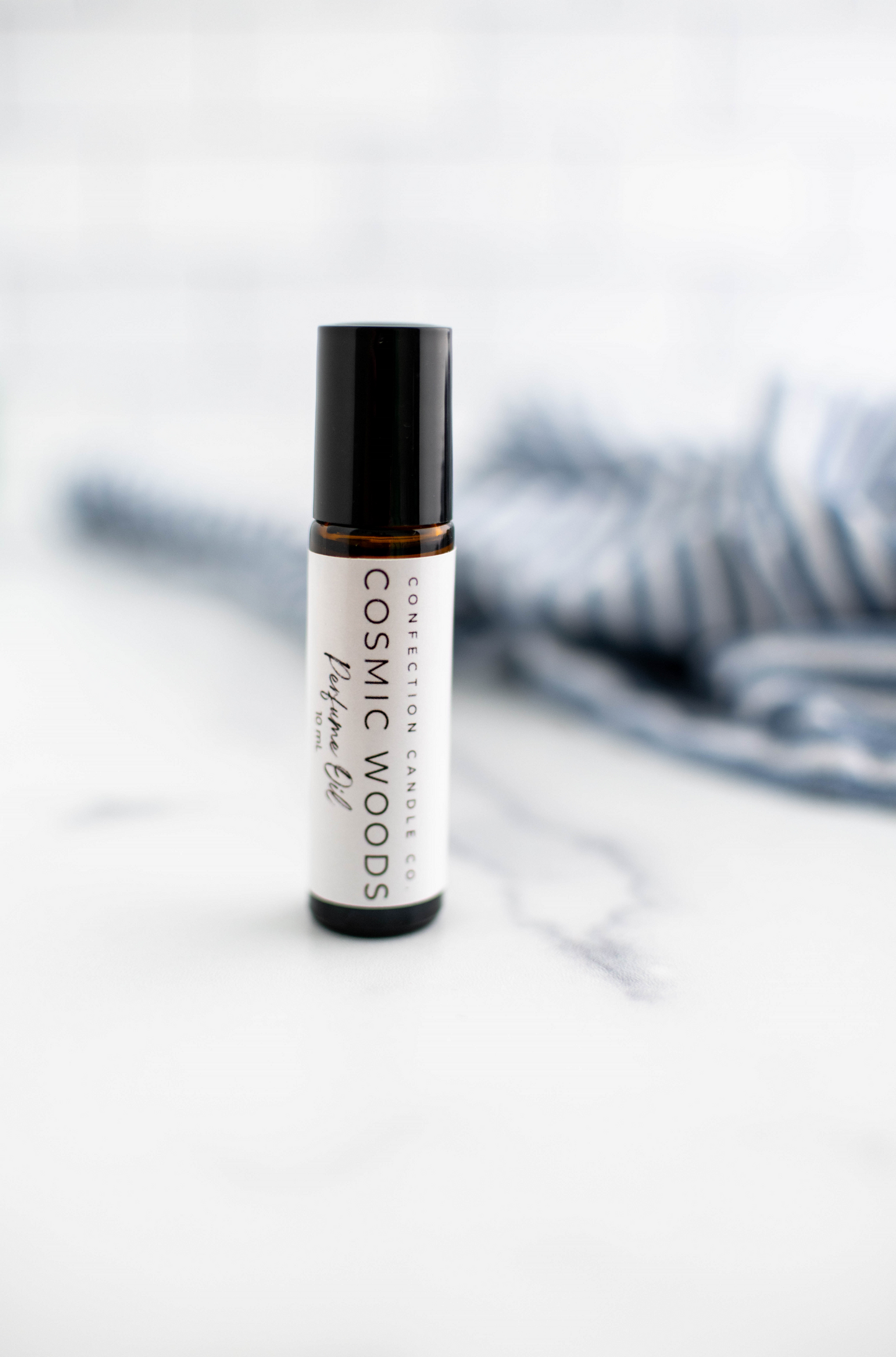 Amber glass roller bottle in the fragrance Cosmic Woods.